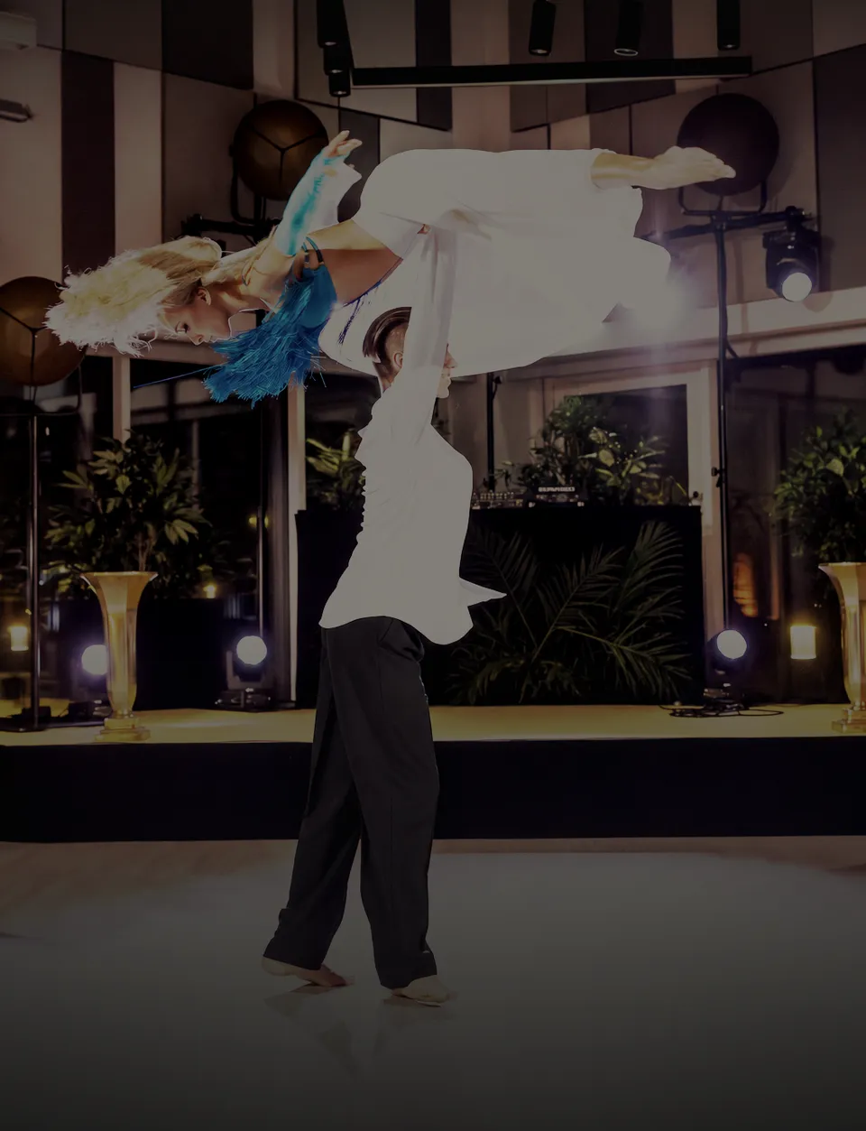 Ballroom and Latin couple performing an overhead lift on stage